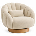 Fauteuil beige enveloppant à dossier cannelé et socle circulaire